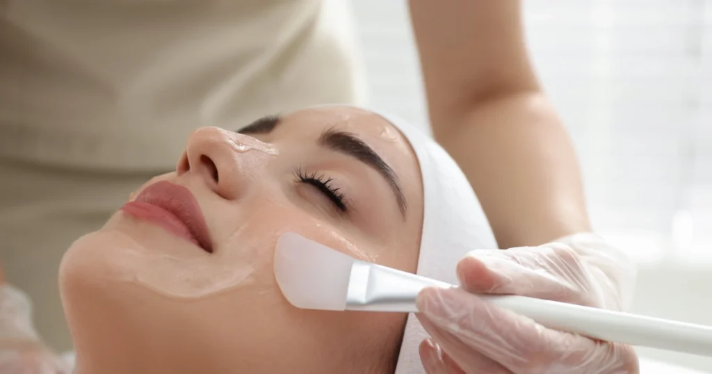 Woman receiving a Cosmelan Peel in Broomfield, CO, with serum applied to her cheek and eyes closed.